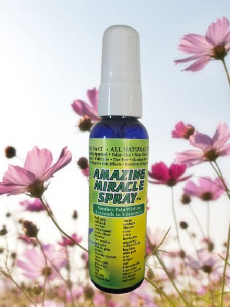 Amazing Miracle Spray bottle over purple flowers on white background