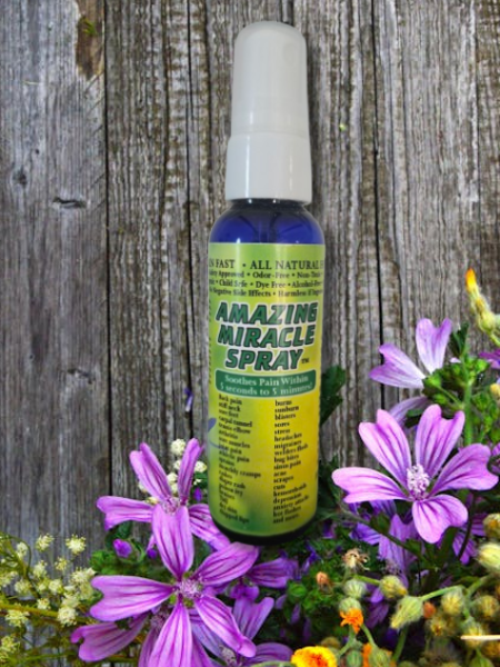 Amazing Miracle Spray in front of weathered board with purple flowers